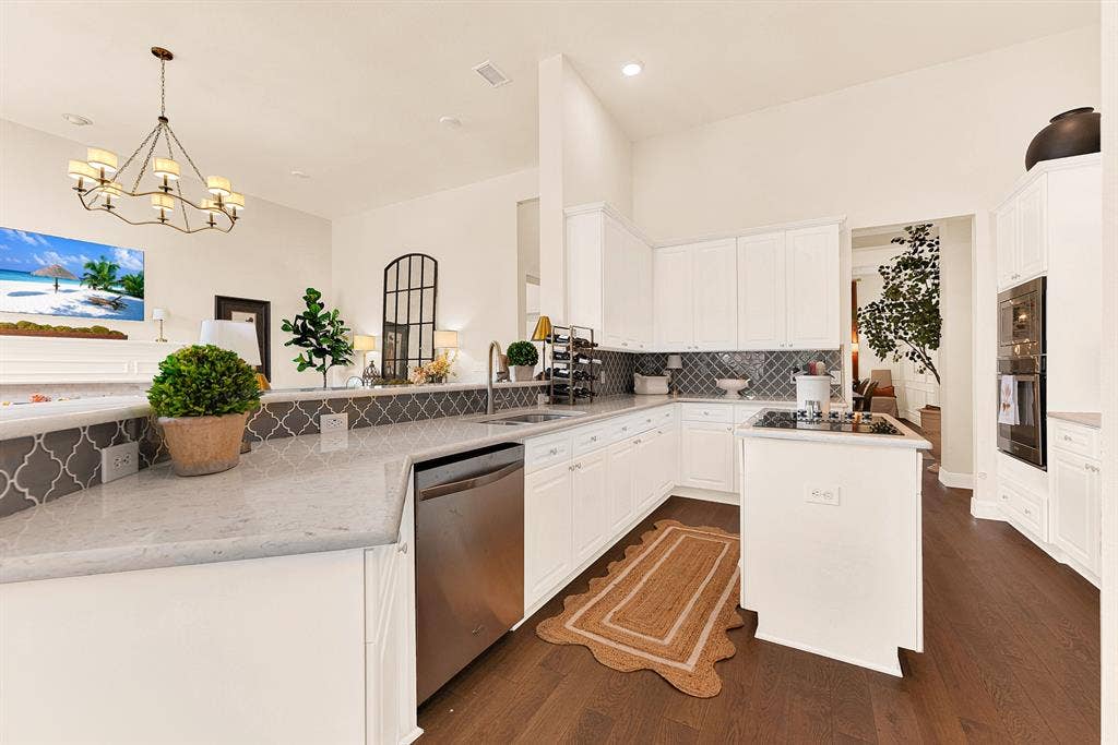 6429 GLENHOLLOW Drive, Plano, TX 75093 Generous quartz counters wrap around the perimeter, creating a sweeping workspace bathed in bright ambient ceiling light. Prep weeknight meals effortlessly while staying connected with family hanging out nearby.