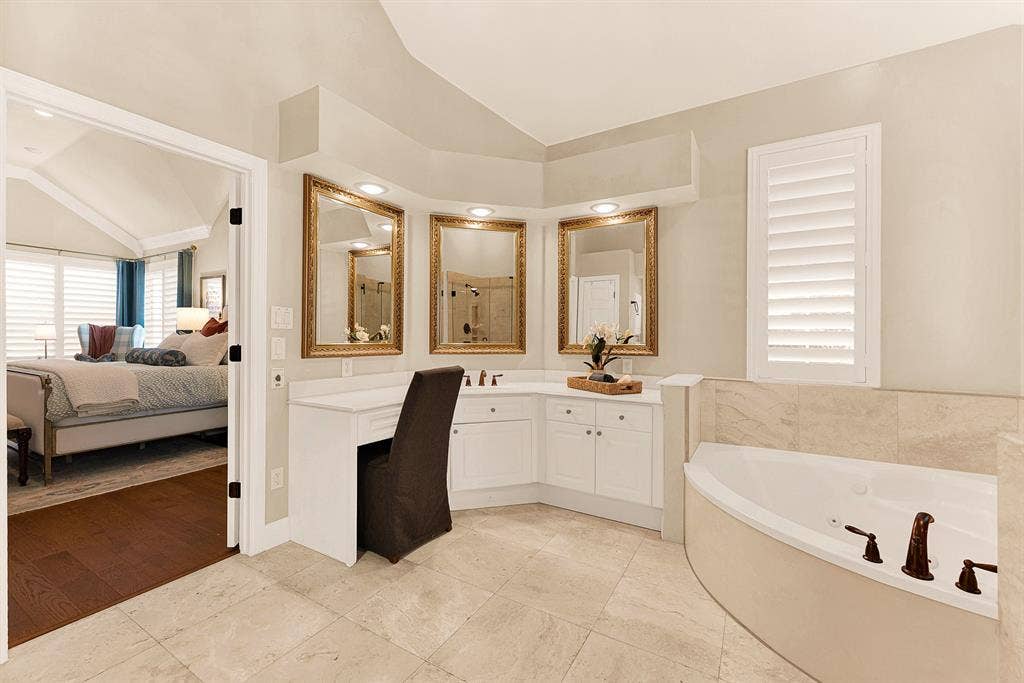 6429 GLENHOLLOW Drive, Plano, TX 75093 An expansive wrap-around vanity with framed mirrors creates a dedicated grooming area reflecting warm ambient light. Imagine taking time for a pampering evening skincare routine before turning in.