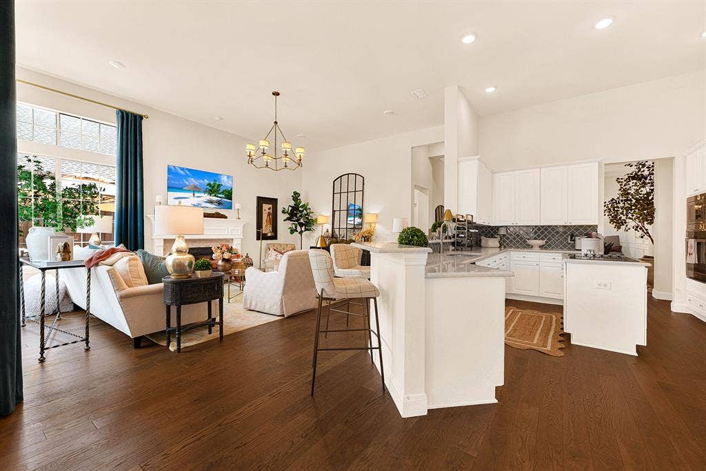 6429 GLENHOLLOW Drive, Plano, TX 75093 An open, two-tiered breakfast bar seamless connects the kitchen workspace directly to the high-ceilinged family room. Enjoy chatting with guests over hors d'oeuvres while putting the finishing touches on dinner.