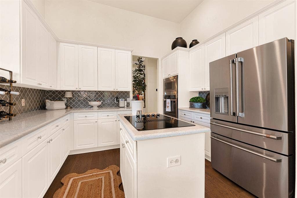 6429 GLENHOLLOW Drive, Plano, TX 75093 An upgraded arabesque backsplash brings rich contrast against crisp cabinetry and sleek stainless steel built-in appliances. Enjoy crafting gourmet recipes using modern cooking features that make hosting a total breeze.