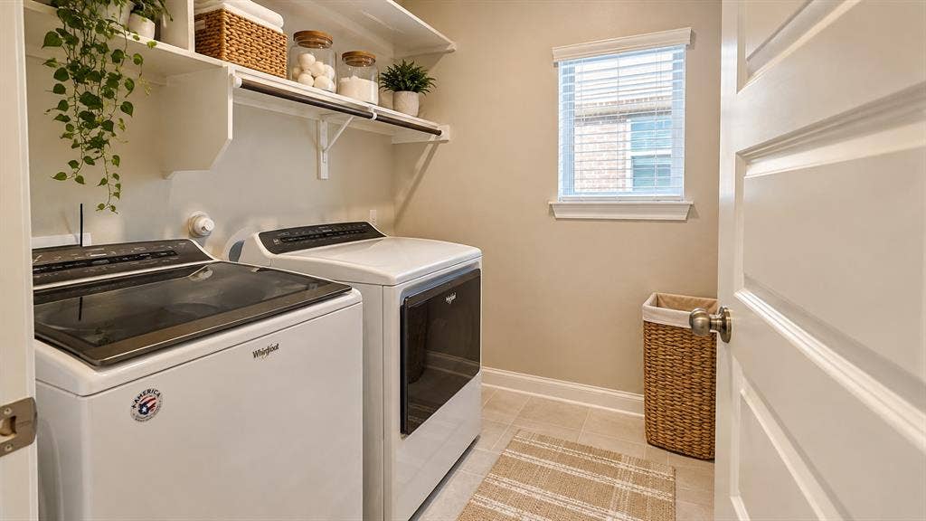 5617 Southern Fern Road, Garland, TX 75043 Laundry area with white top-load washing machine, front-load dryer, and wall-mounted shelving