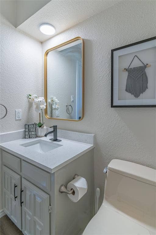 1011 Wimbledon Lane, Plano, TX 75075 Vanity with a light-toned countertop, matte black faucet, and white cabinetry with black hardware