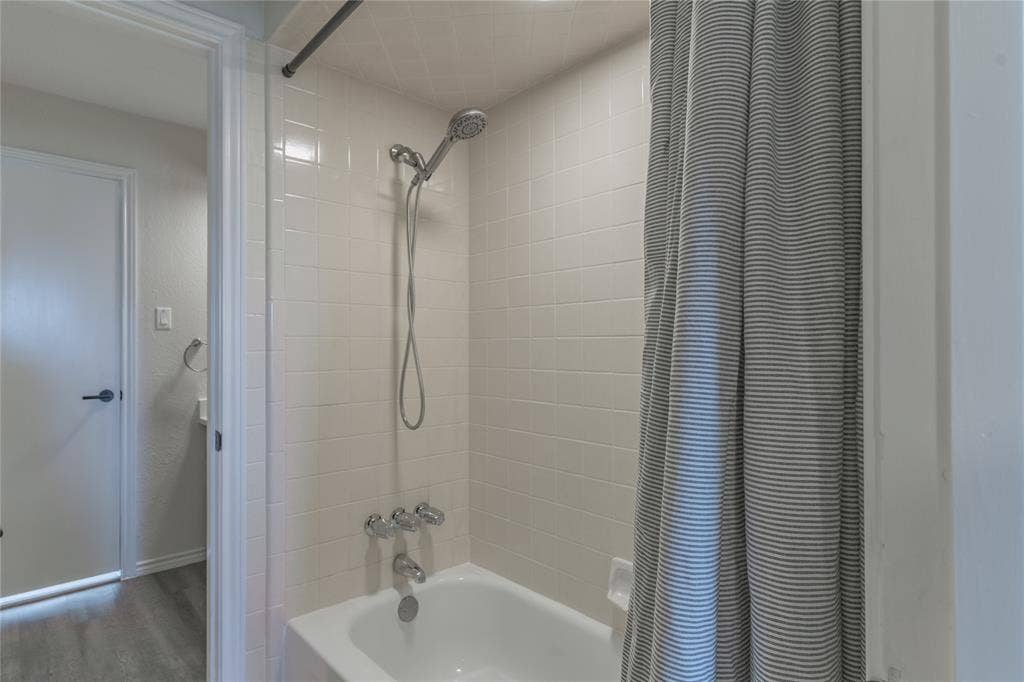 1011 Wimbledon Lane, Plano, TX 75075 White subway tile shower surround with a fixed showerhead and hand shower