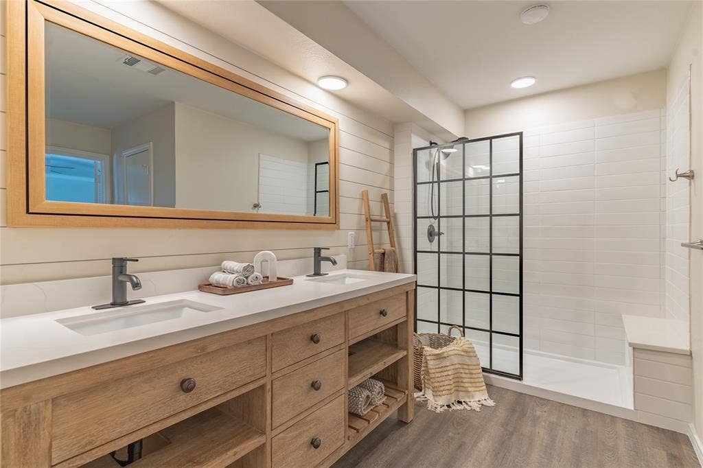 1011 Wimbledon Lane, Plano, TX 75075 Dual vanity with natural wood-finish cabinetry, white countertop, and integrated sinks