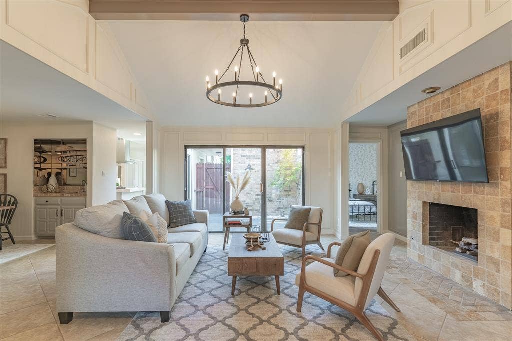 1011 Wimbledon Lane, Plano, TX 75075 Vaulted ceiling with exposed beam, tile flooring, stone-tiled fireplace, built-in wet bar, and sliding glass door