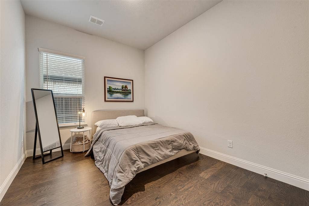 812 Stamford Avenue, Arlington, TX 76002 Vaulted ceiling with a white finish, single window with blinds, dark wood-finish flooring, and white walls
