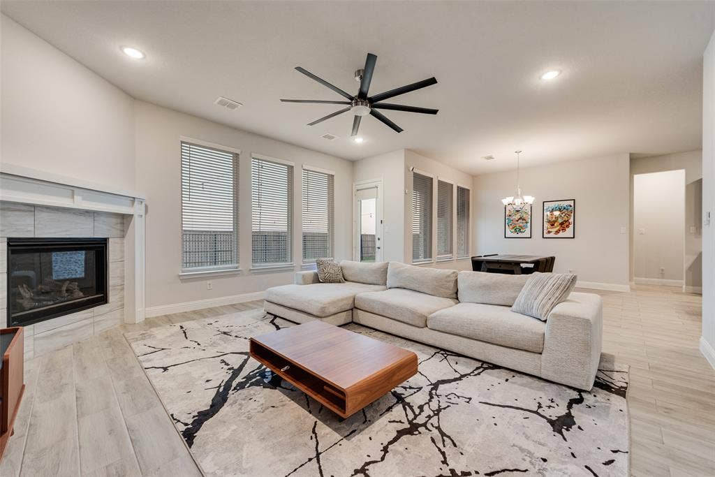 812 Stamford Avenue, Arlington, TX 76002 Spacious living area featuring wood-finish flooring, a tiled fireplace with a mantel, and multiple large windows