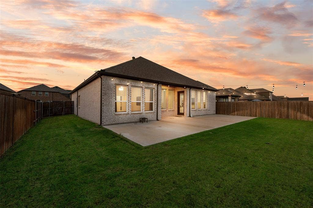 812 Stamford Avenue, Arlington, TX 76002 Expansive backyard featuring a manicured lawn, concrete patio, and privacy fencing