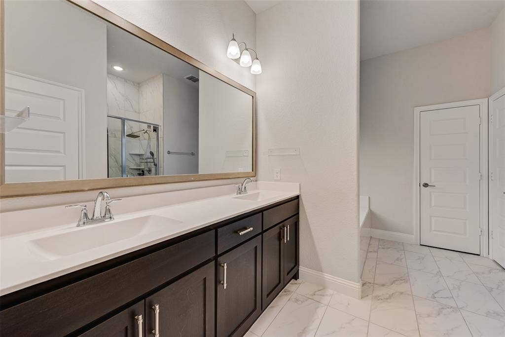 812 Stamford Avenue, Arlington, TX 76002 Double vanity featuring integrated sinks, dark wood-finish cabinetry, and chrome fixtures