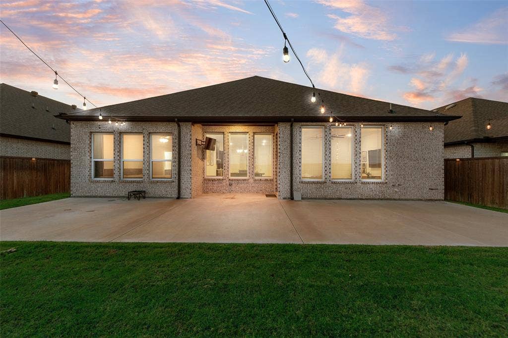 812 Stamford Avenue, Arlington, TX 76002 Expansive concrete patio with string lighting and a brick exterior