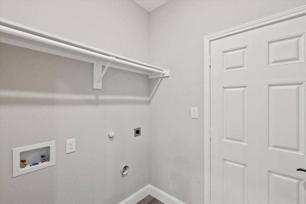 7919 N kiska Street, Dallas, TX 75216 Dedicated laundry area featuring a built-in hanging rod, wall-mounted electrical outlets, and plumbing hookups