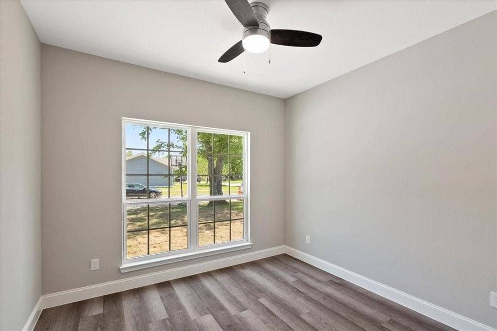 7919 N kiska Street, Dallas, TX 75216 Vaulted ceiling with a ceiling fan, wood-finish flooring, and a multi-pane window