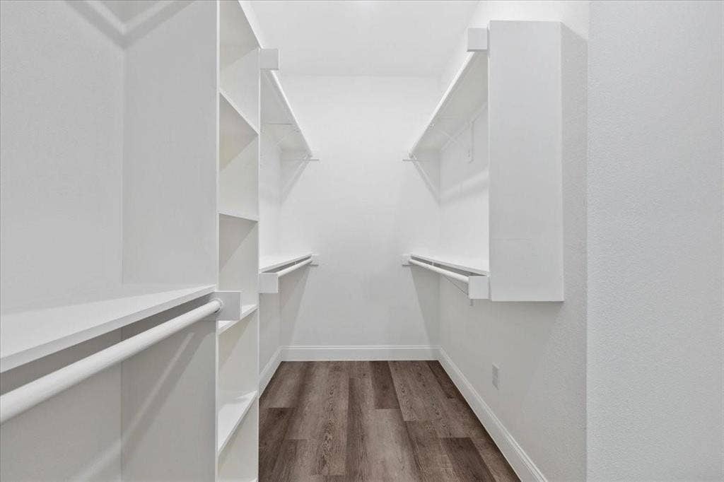 7919 N kiska Street, Dallas, TX 75216 Walk-in closet with integrated shelving, hanging rods, and wood-finish flooring