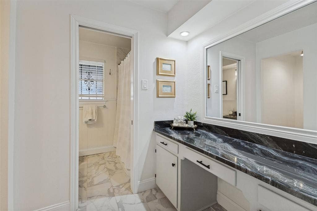 9864 Shoreview Road, Dallas, TX 75238 White cabinetry with dark hardware and a black patterned countertop