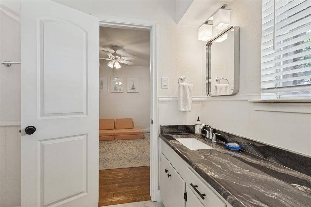 9864 Shoreview Road, Dallas, TX 75238 Vanity with dark, patterned countertop, undermount sink, and chrome faucet