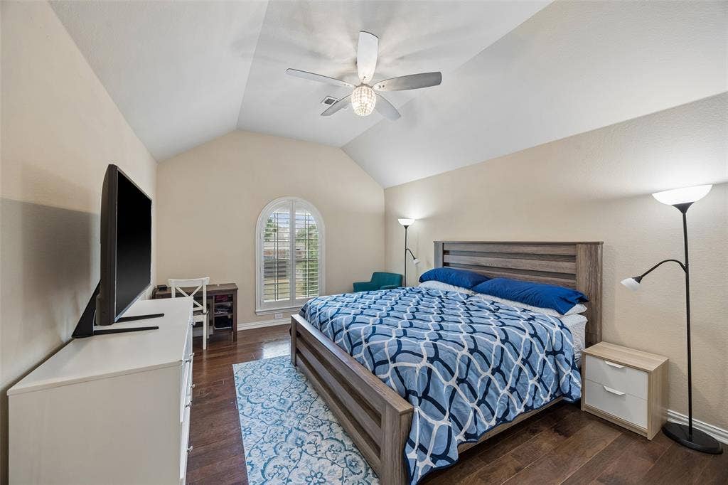 2865 Ridge View Road, Frisco, TX 75034 Vaulted ceiling with a ceiling fan, arched window with plantation shutters, wood-finish flooring, and neutral wall tones