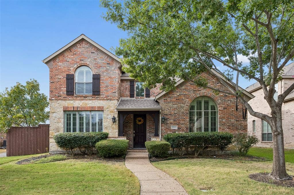 2865 Ridge View Road, Frisco, TX 75034 Brick and stone exterior featuring an arched window, bay window, dark shutters, and a covered entry