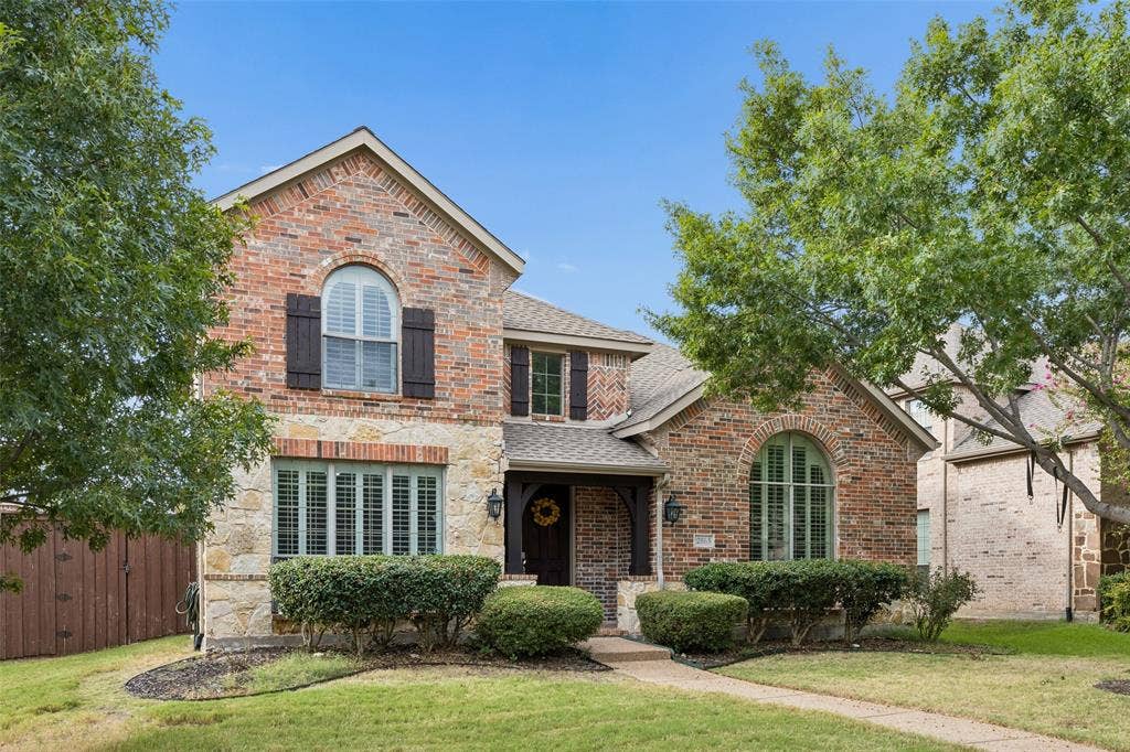 2865 Ridge View Road, Frisco, TX 75034 Brick and stone exterior with arched windows, dark shutters, and a covered entry