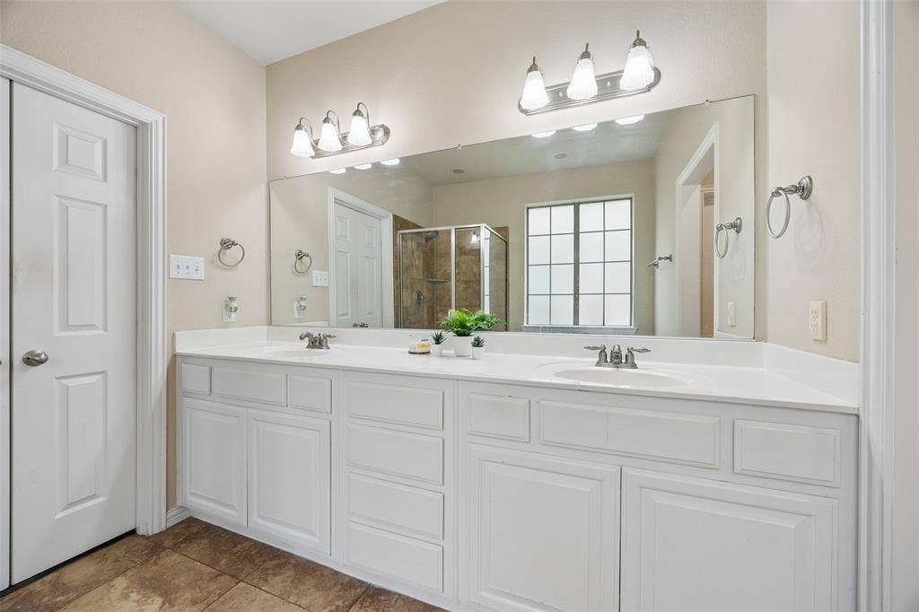 2865 Ridge View Road, Frisco, TX 75034 Dual vanity with white cabinetry, integrated sinks, brushed nickel fixtures, and a large wall-mounted mirror