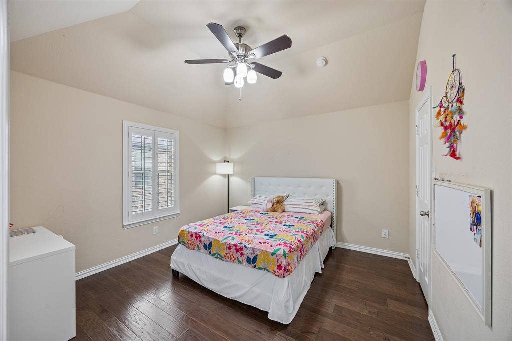 2865 Ridge View Road, Frisco, TX 75034 Vaulted ceiling with a ceiling fan, wood-finish flooring, white window shutters, and a white door