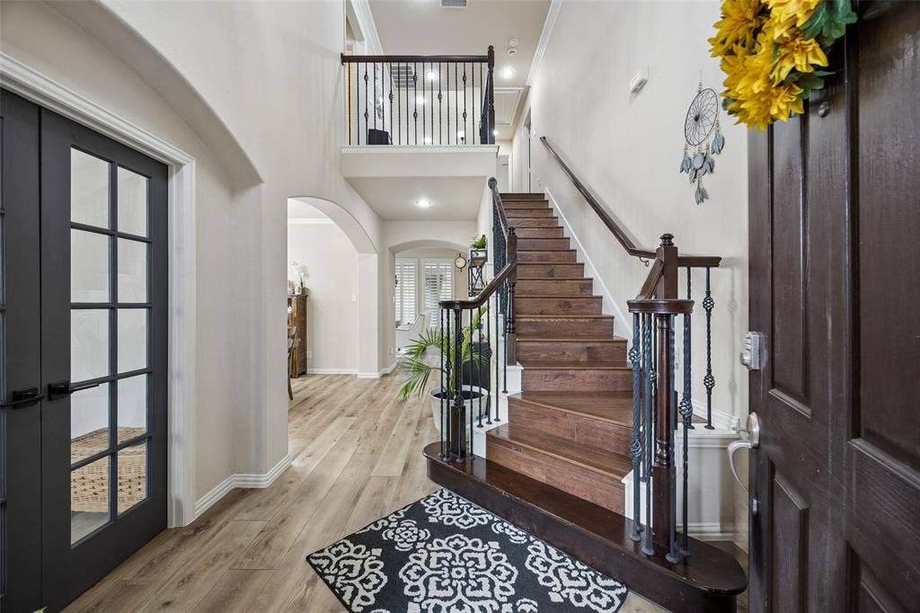2865 Ridge View Road, Frisco, TX 75034 Wood-finish flooring throughout the entry, a dark wood staircase with wrought iron balusters, and a second-level landing with matching balusters
