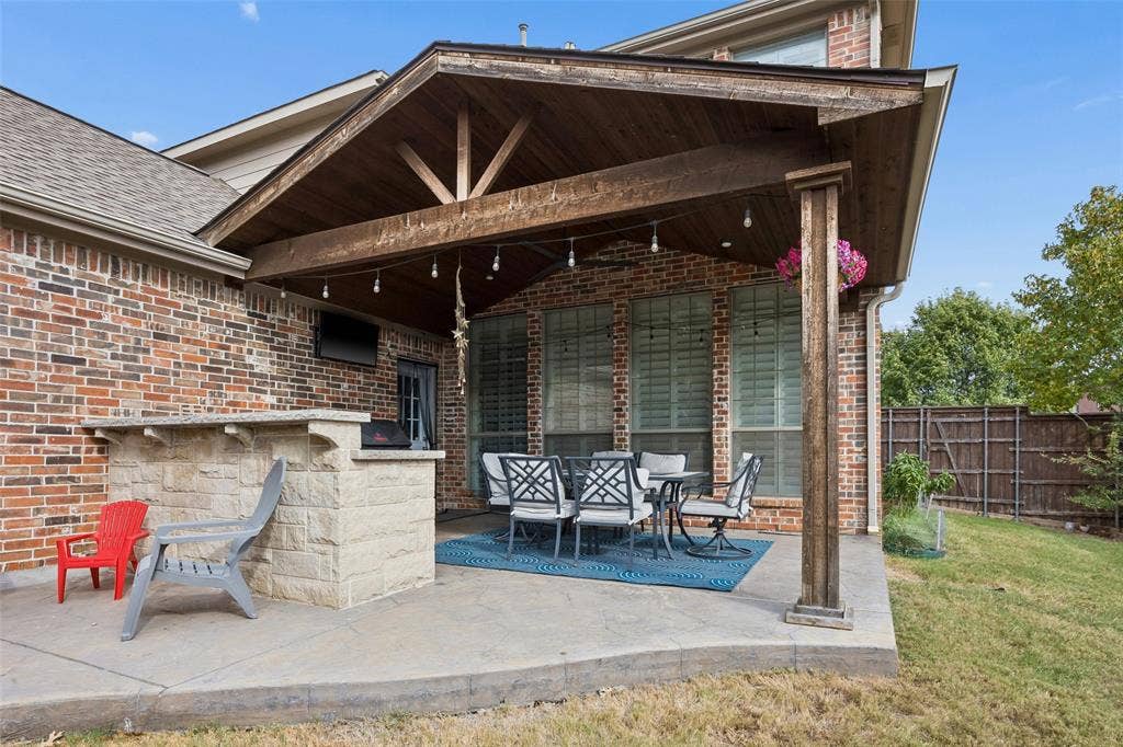 2865 Ridge View Road, Frisco, TX 75034 Covered patio with a wood-plank ceiling, exposed wood beams, and a built-in stone bar