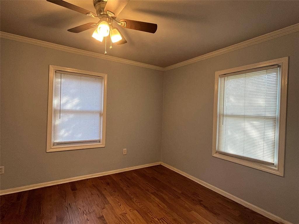 Hardwood-style flooring, crown molding, and a ceiling fan with integrated lighting