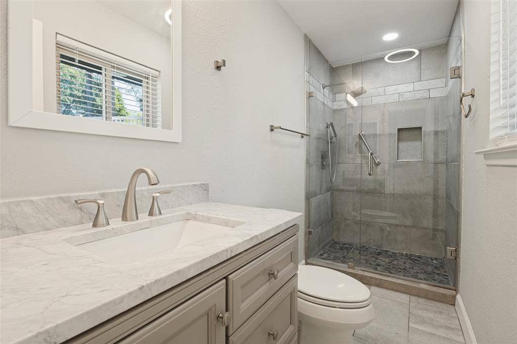 Vanity with a marble-finish countertop, undermount sink, and brushed nickel faucet