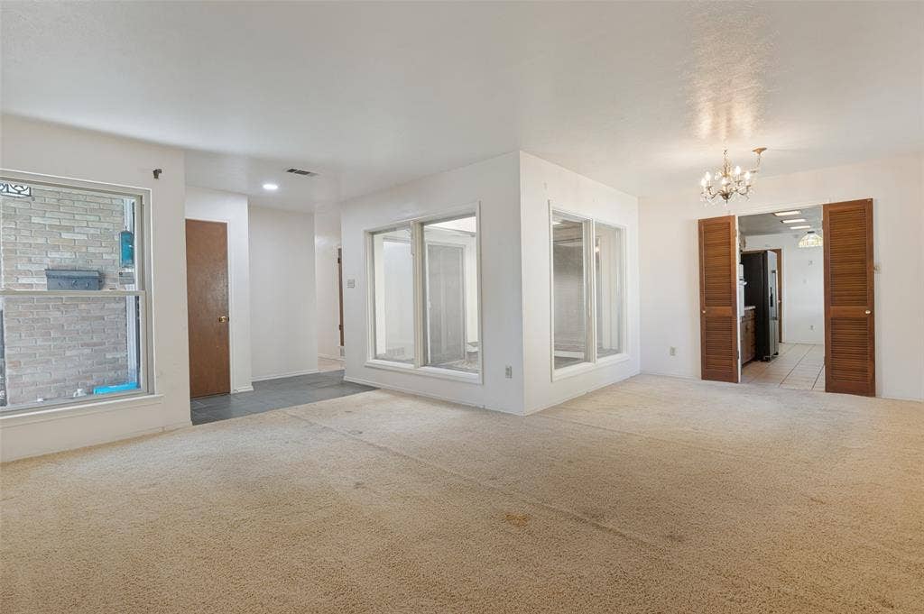 Recessed lighting, chandelier, multiple windows, interior accordion doors, and tile flooring