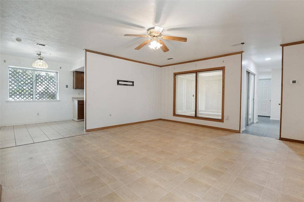 Spacious room with neutral tile flooring