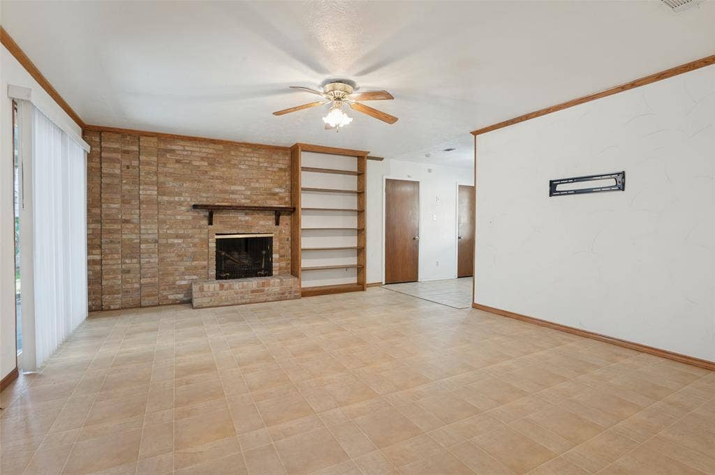 Brick fireplace with a dark wood mantel and built-in shelving