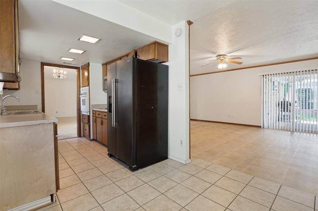 Kitchen featuring tile flooring, built-in appliances, and wood cabinetry