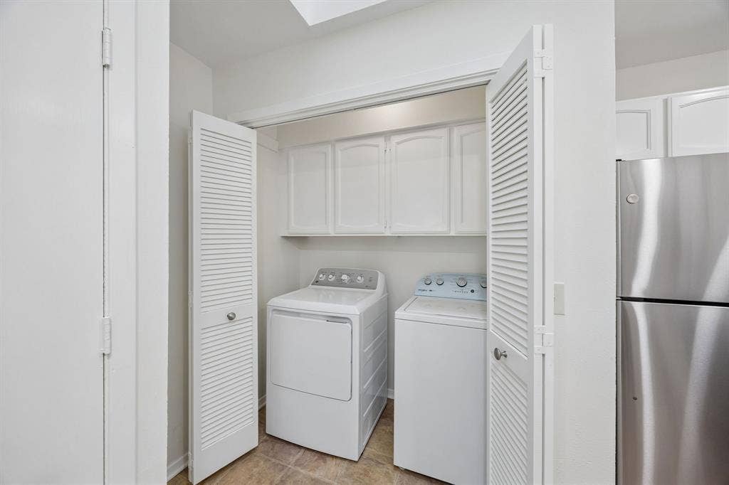 1613 19th Street, Plano, TX 75074 Laundry area with built-in cabinetry, louvered bi-fold doors, and tile flooring