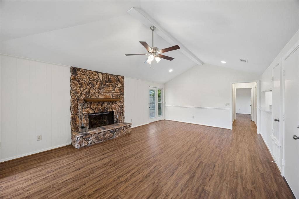 1613 19th Street, Plano, TX 75074 Vaulted ceiling, wood-finish flooring, stone fireplace with hearth, ceiling fan with light fixture, and French door