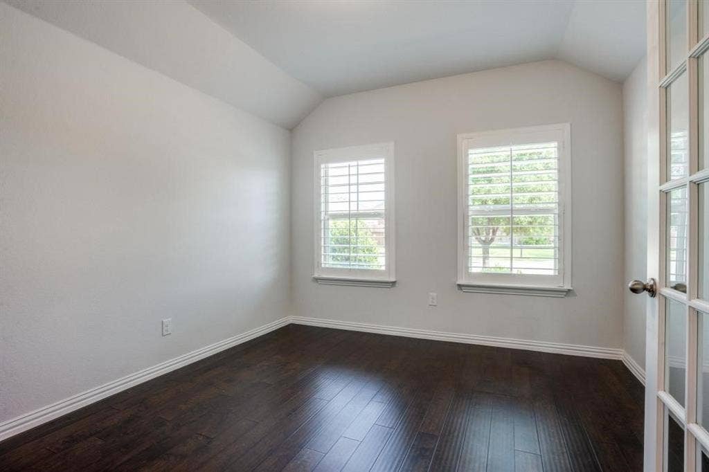 6229 Gloucester Drive, Celina, TX 76227 Vaulted ceiling, two windows with plantation shutters, dark wood-finish flooring, and a French door entry