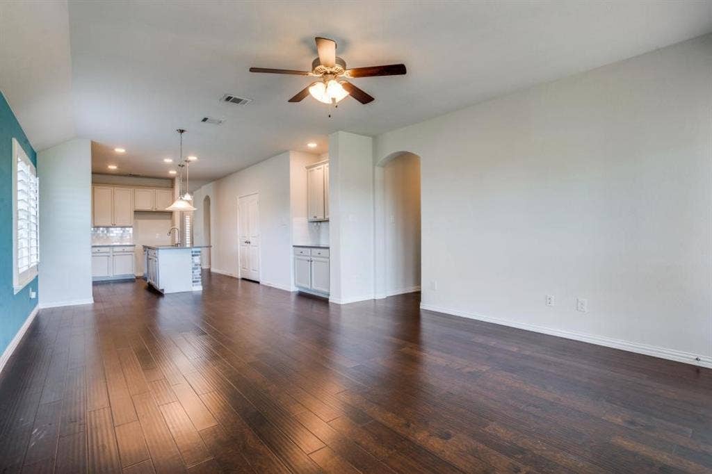 6229 Gloucester Drive, Celina, TX 76227 Dark wood-finish flooring throughout, a ceiling fan with integrated lighting, and a kitchen island with pendant lighting
