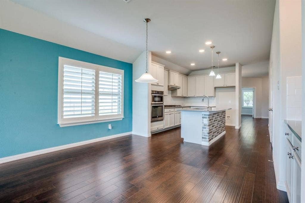 6229 Gloucester Drive, Celina, TX 76227 Kitchen and dining area featuring wood-finish flooring, vaulted ceiling, recessed lighting, and a kitchen island with stone tile detailing