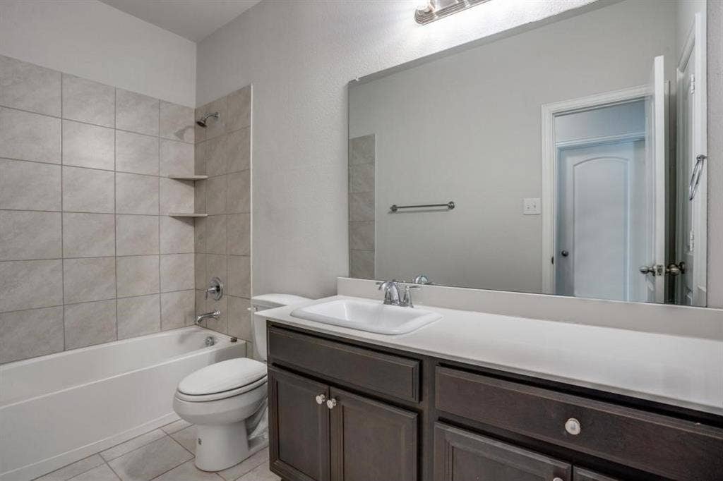 6229 Gloucester Drive, Celina, TX 76227 Vanity with a white countertop and integrated sink, chrome faucet, and dark wood-finish cabinetry