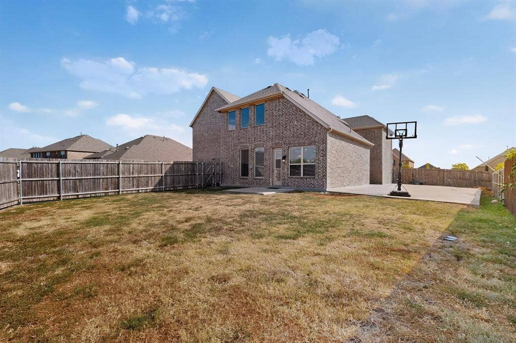 Brick exterior with multiple windows and a concrete patio