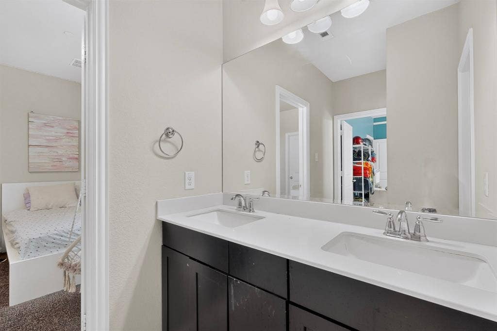 Dual vanity with white countertop, integrated sinks, and dark wood-finish cabinetry