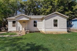 7729 Hillard Drive, Dallas, TX 75217 Single-story home featuring light-colored siding and an expansive front lawn