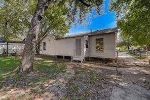 7729 Hillard Drive, Dallas, TX 75217 Single-story residence with a white wood siding exterior, a screen door entrance, and a sloped roof