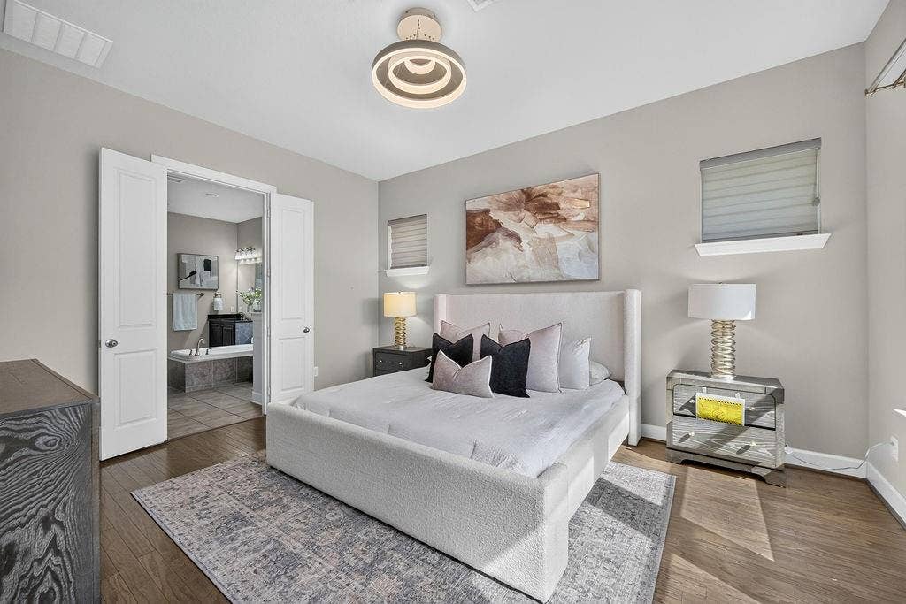 Neutral-toned walls, wood-finish flooring, and a modern circular tiered flush-mount light fixture