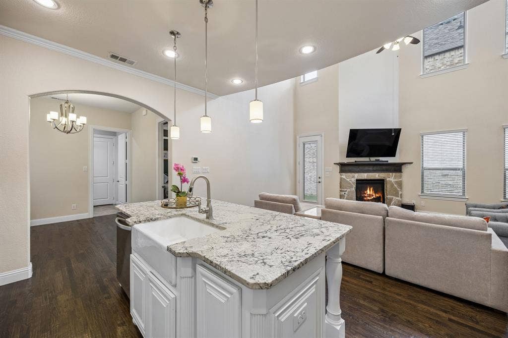 Kitchen with large island, farm sink, and views of breakfast area and downstairs living room