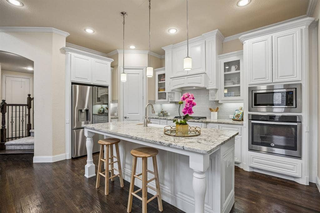 Kitchen with large island, granite counter tops, stainless appliances, gas range and walk-in pantry