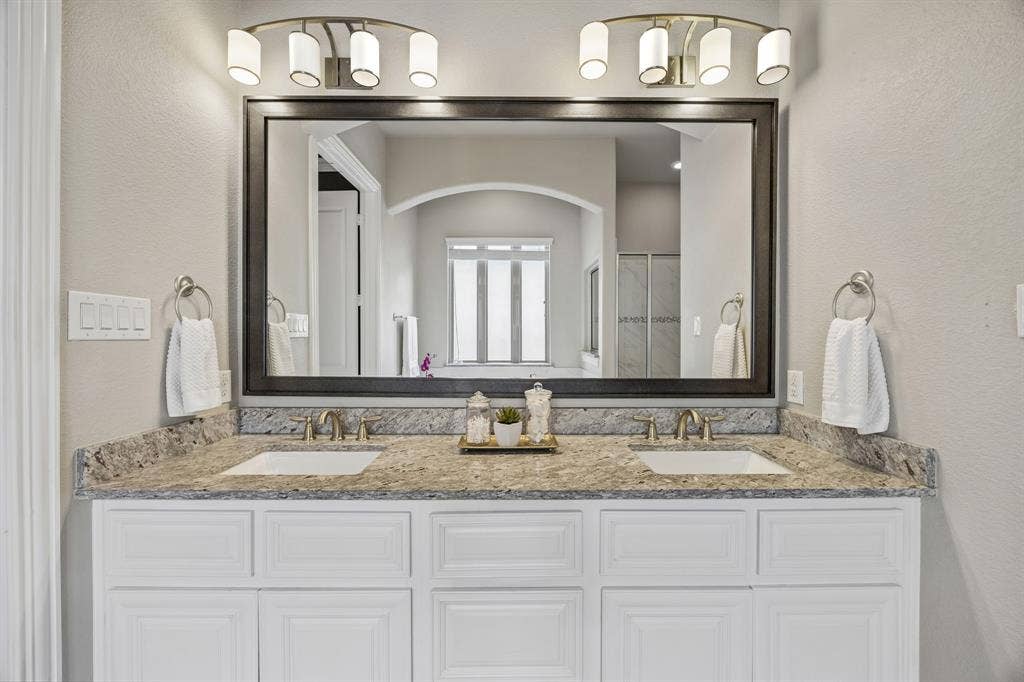 Primary bathroom vanity with double sinks and granite counter top