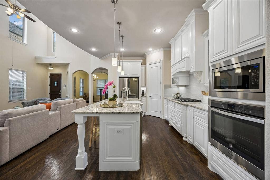 Kitchen with large island, gas range, custom cabinetry and walk-in pantry
