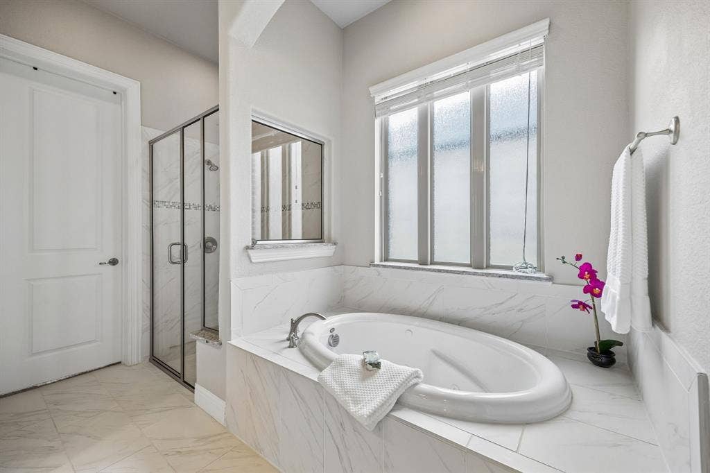 Primary bathroom with garden tub, walk-in shower and large primary closet