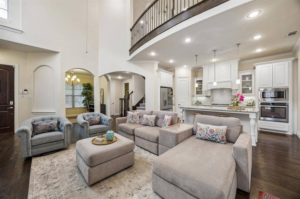 Living room with view of chef's kitchen and upstairs game room/living room