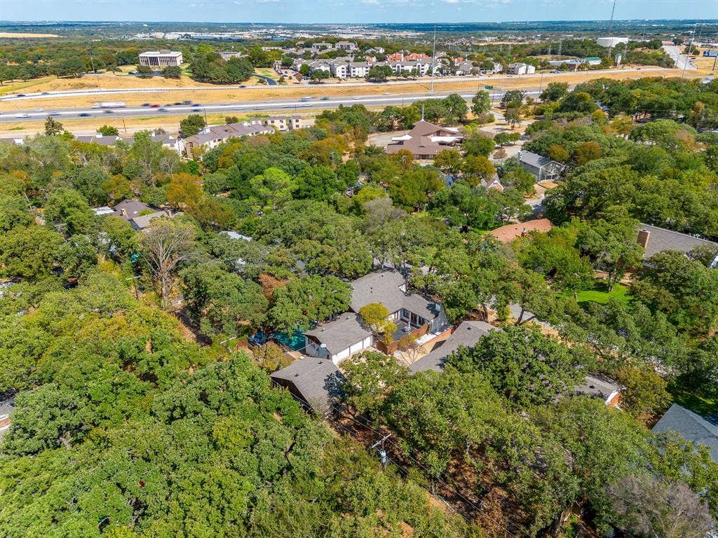 Lush tree canopy surrounds the property, offering extensive natural landscaping